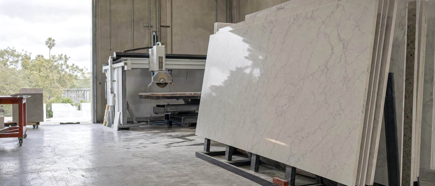 Engineered quartz slabs on steel racks in a countertop fabrication shop, the kind of workplace behind most new silicosis claims